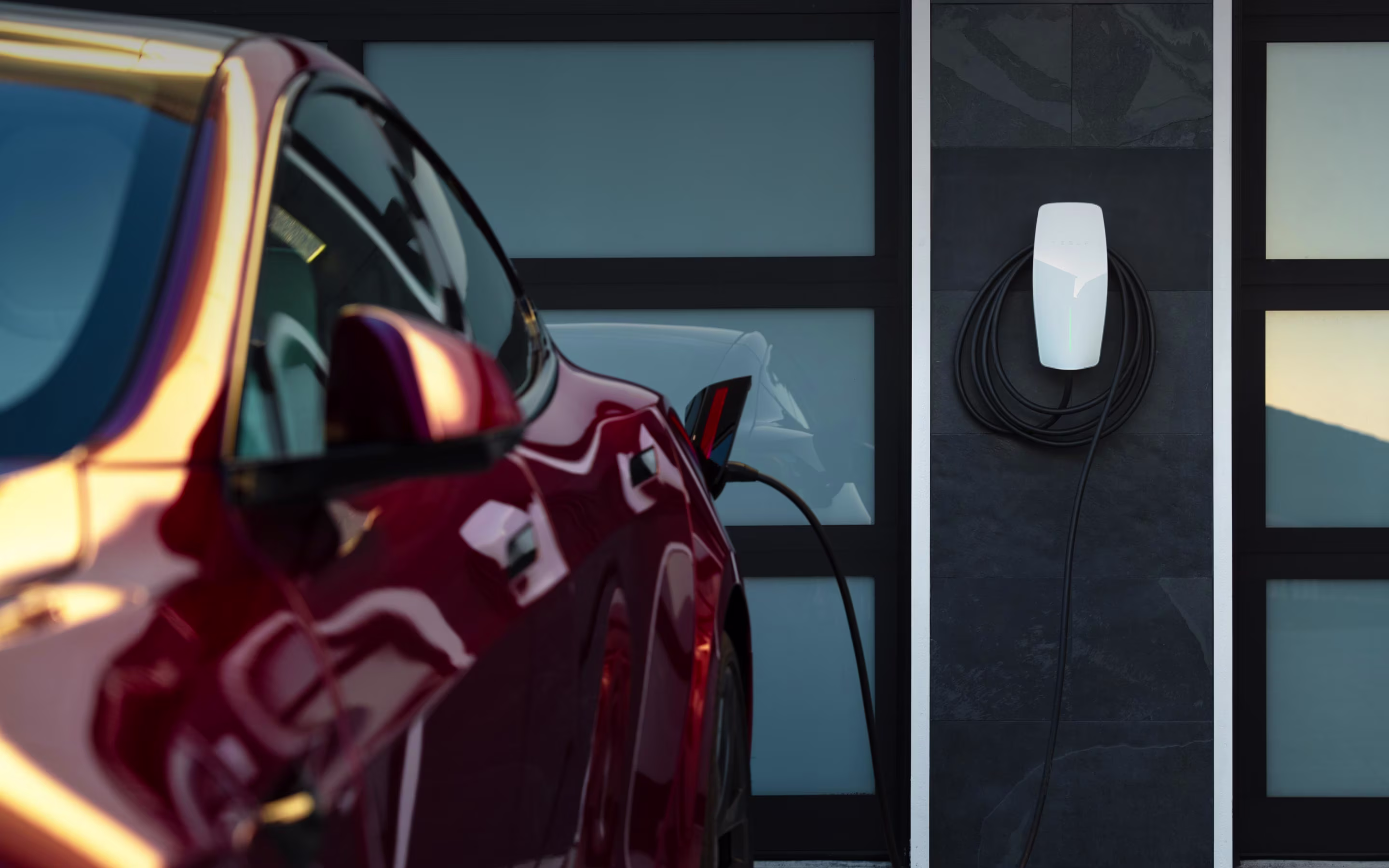 Tesla Wall Connector duvara monte, araç garajda şarj oluyor